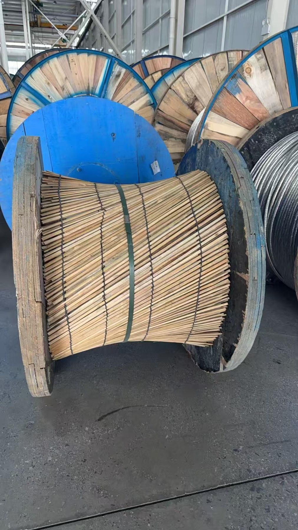 Transport drums protected with wooden slat guards in a warehouse